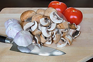 Mushrooms Tomatoes Garlic Cloves Kitchen Knife on Cutting Board
