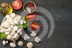 mushrooms with tomatoes, parsley, oil, garlic, chili pepper, peppercorns on dark wooden background. top view