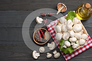 mushrooms with tomatoes, parsley, oil, garlic, chili pepper, peppercorns on dark wooden background. top view