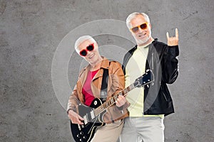 Senior couple with guitar showing rock hand sign