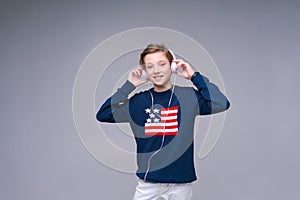 Music app. Cute kid using phone with headphones, listening to great song