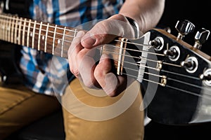 Music and art. Electric guitar in the hands of a guitarist, on a black isolated background. Playing guitar. Horizontal frame