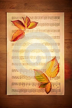 The Music of Autumn. Vibrant fall leaves on a piece of aged sheet music