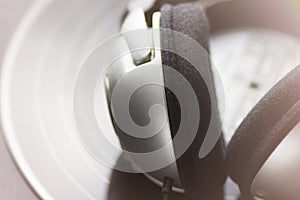 Music Background. Silver Headphones Lying on Vintage Vinyl Long Play Record Black Background. Entertainment Abstract Concept