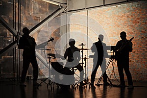 Music band and fashion. Handsome young men in suits playing rock and singing song. Bands silhouettes with on a concert.