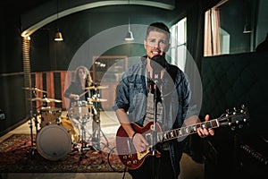 Music band having rehearsal in a studio