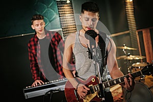 Music band having rehearsal in a studio