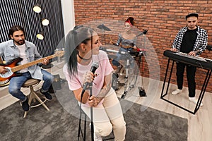 Music band performing in modern recording studio