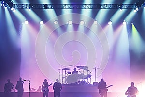 Music Band on Stage, Silhouettes at a Music Concert in Front of Bright Lights. Vintage Style. The Concept of Active Nightlife,