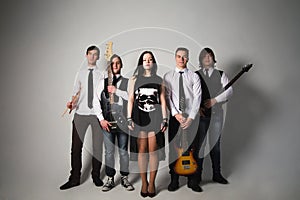 music band in studio.Musicians and woman soloist posing over white background photo