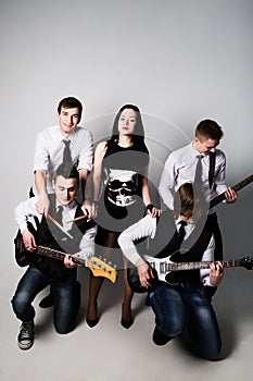 music band in studio.Musicians and woman soloist posing over white background photo