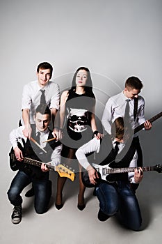 music band in studio.Musicians and woman soloist posing over white background