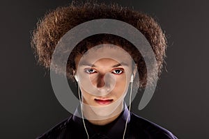 Music and bushy afro hairstyle on teenager boy