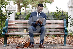 Music, business and black man on tablet at park for research, social media or consultant reading email. Tech, earphones