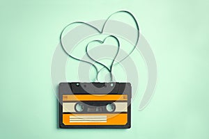 Music cassette and hearts made with tape on turquoise background, top view. Listening love song