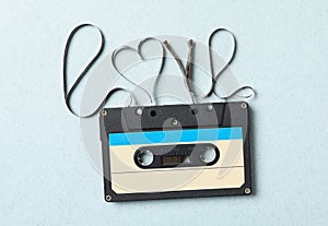 Music cassette and word Love made with tape on turquoise background, top view. Romantic song