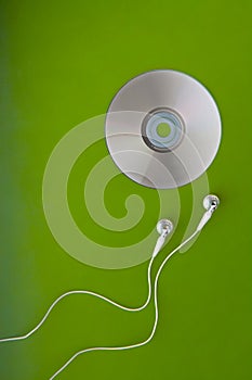 Music CD headphones or earphones on green