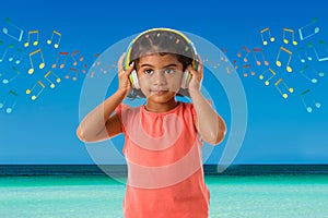 Music, childhood and technology concept- little indian girl with headphones over sea view backgroundound with musical notes
