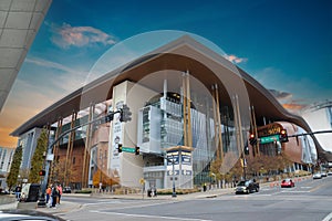 Music City Center surrounded by gorgeous yellow and green autumn trees, people walking along the sidewalk and cars driving