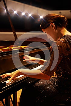 Music, concert and woman with piano on a stage for performance, entertainment and talent show. Musician, creative art
