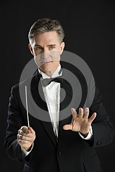 Music Conductor Gesturing While Directing With His Baton photo