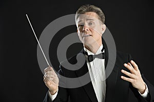 Music Conductor Looking Away While Directing With His Baton photo