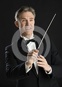 Music Conductor Smiling While Directing With His Baton