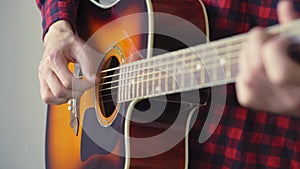 Music, creativity, concert, self-isolation concept. Close-up hands of young man playing an acoustic guitar dreadnought