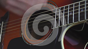 Music, creativity, concert, self-isolation concept. Close-up hands of young man playing an acoustic guitar dreadnought