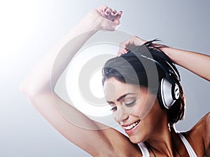 Music, dance and happy woman with headphones in studio with freedom, party and celebration. Dancer, performance and