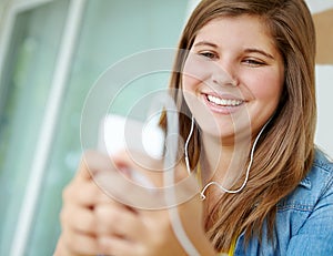 Music gets her amped. A pretty teenager choosing a song on her mp3 player.