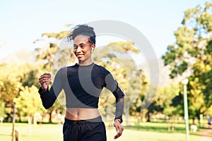 Music helps me with my pace. an attractive young woman running in the park on her own during the day.