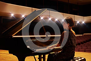 Music is her artform. Shot of a young woman playing the piano during a musical concert.
