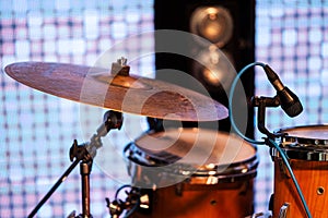 MUSIC INSTRUMENTS DRUMS AND MICROPHONE ON STAGE, IN BACKGROUND LIGHT BARS.