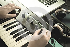 Music keyboard player is adjusting sound synthesizer