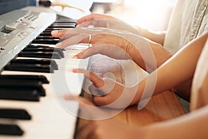 Music lesson, hands of child and piano teacher on keys for development and education together with tutor. Fingers