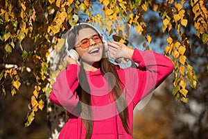 Music lifestyle of teen girl singing and wear headphones in autumn or fall park outdoor