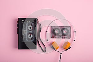 Music listening concept. Vintage cassette tape, audio player and headphones close-up on pink background, top view