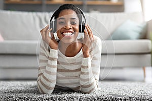 Music Lover. Portrait Of Cheerful Black Woman In Wireless Headphones At Home