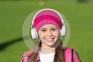 Music makes you smarter. Happy girl listen to music sunny outdoors. Little kid wear headphones playing music. Summer