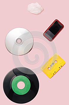 Music mediums over time concept. EP and LP vinyl, cassette tape, CD, mp3 player, cell phone, portable speaker cotton cloud shaped photo