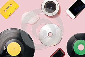 Music mediums over time concept. EP and LP vinyl, cassette tape, CD, mp3 player, cell phone, portable speaker cotton cloud shaped photo