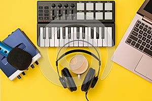 Music mixer,microphone, headphones and sound card on yellow background. The concept of workplace organization