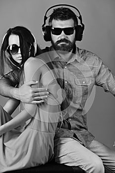 Music, party and leisure concept. Couple in love wears headphones and sunglasses. Music fans