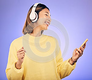 Music, phone and happy Asian woman in studio for social media, internet meme and online chat. Headphones, smile and
