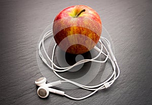 Music playing apple in which earphones are connected.