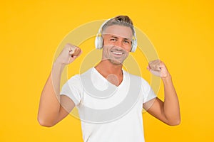 Music is power. Happy man flex arms yellow background. Audio power. Listening to music. Headphones technology. Modern