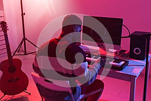 Music production concept - Male sound producer working in home recording studio.