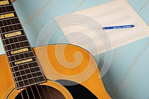 Music recording scene with guitar, empty music sheet and pencil