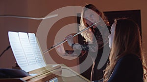 Music rehearsal - female flutist and organist playing music in christian church